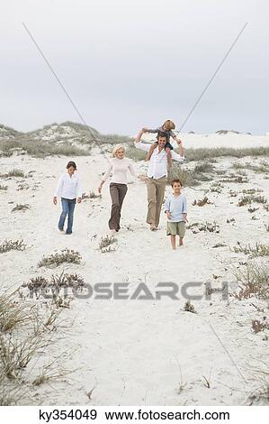 Couple walking on the beach with their children View Large Photo Image Stock Photo - Couple walking on the beach with their children. Fotosearch