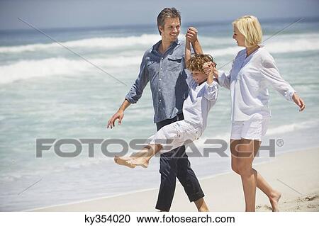 Couple walking with their son on the beach View Large Photo Image Stock Image - Couple walking with their son on the beach. Fotosearch