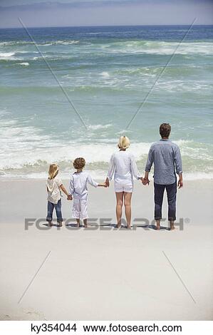 Couple with their children standing on the beach View Large Photo Image Picture - Couple with their children standing on the beach. Fotosearch