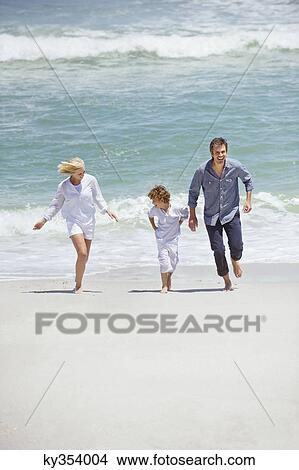Picture - Couple with their son running on the beach. Fotosearch