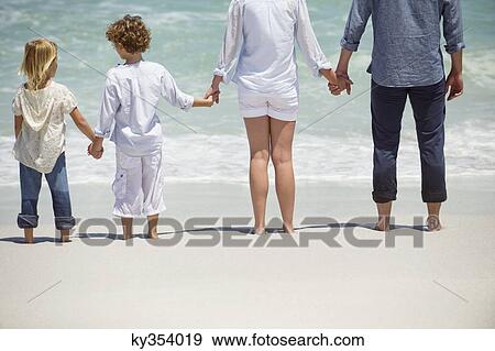 Couple with two children standing on the beach View Large Photo Image Stock Photo - Couple with two children standing on the beach. Fotosearch