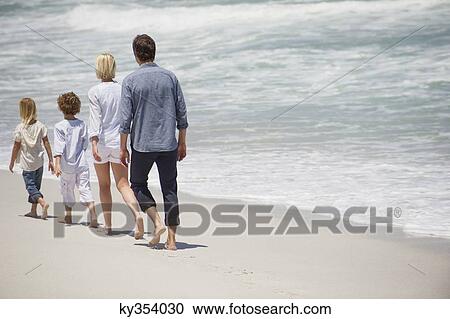 Couple with two children walking on the beach View Large Photo Image Stock Image - Couple with two children walking on the beach. Fotosearch