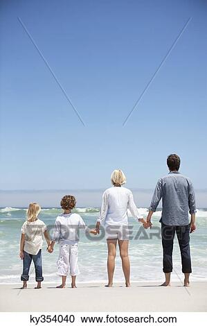 Stock Image - Family looking at sea view from beach. Fotosearch