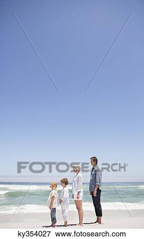 Stock Photo - Family standing on the beach. Fotosearch