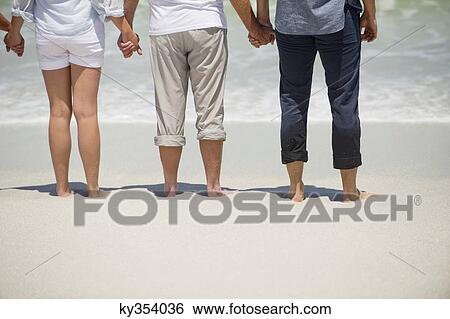 Family standing on the beach View Large Photo Image Stock Photograph - Family standing on the beach. Fotosearch