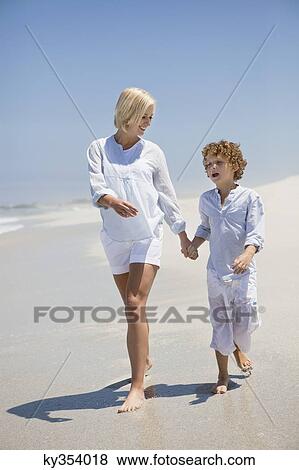 Woman walking on the beach with her son View Large Photo Image Stock Photo - Woman walking on the beach with her son. Fotosearch