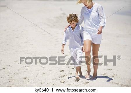 Woman walking with her son on the beach View Large Photo Image Stock Image - Woman walking with her son on the beach. Fotosearch