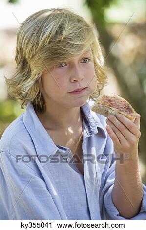 Contemplative little boy looking away while eating bread outdoors View Large Photo Image Stock Image - Contemplative little boy looking away while eating bread outdoors. Fotosearch
