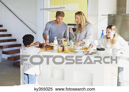 Couple with their two children preparing food at a domestic kitchen View Large Photo Image Stock Photography - Couple with their two children preparing food at a domestic kitchen. Fotosearch