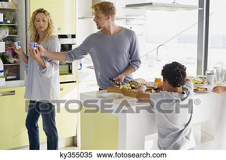 Couple with their two children preparing food at a domestic kitchen View Large Photo Image Stock Photography - Couple with their two children preparing food at a domestic kitchen. Fotosearch