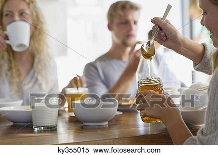 Family eating breakfast at home with focus on a girl taking out honey View Large Photo Image Stock Photography - Family eating breakfast at home with focus on a girl taking out honey. Fotosearch