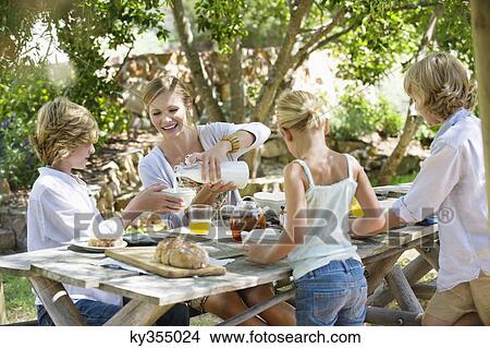 Family having food at front or back yard View Large Photo Image Picture - Family having food at front or back yard. Fotosearch