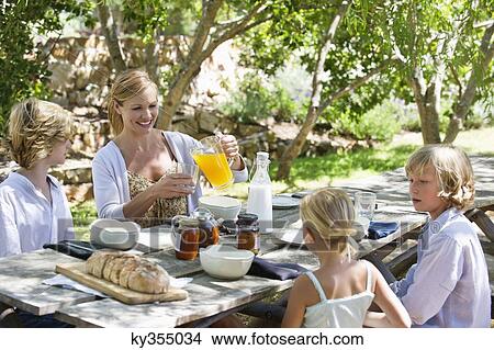 Family having food at front or back yard View Large Photo Image Picture - Family having food at front or back yard. Fotosearch