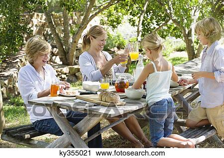 Family having food at front or back yard View Large Photo Image Stock Image - Family having food at front or back yard. Fotosearch
