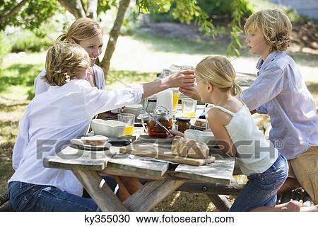 Family having food at front or back yard View Large Photo Image Stock Image - Family having food at front or back yard. Fotosearch