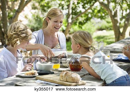 Family having food at front or back yard View Large Photo Image Stock Photo - Family having food at front or back yard. Fotosearch