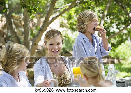 Family having food at front or back yard View Large Photo Image Stock Photograph - Family having food at front or back yard. Fotosearch