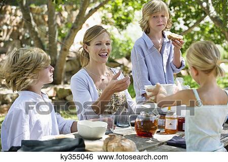 Family having food at front or back yard View Large Photo Image Stock Photograph - Family having food at front or back yard. Fotosearch