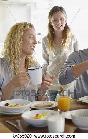 Girl having breakfast with their parents View Large Photo Image Stock Image - Girl having breakfast with their parents. Fotosearch