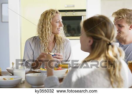 Girl with her parents having breakfast at a dining table View Large Photo Image Stock Image - Girl with her parents having breakfast at a dining table. Fotosearch