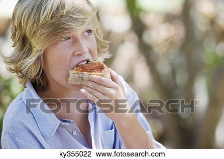 Little boy eating bread outdoors View Large Photo Image Stock Image - Little boy eating bread outdoors. Fotosearch