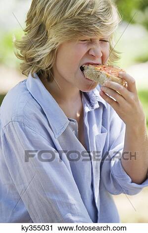 Little boy eating bread outdoors View Large Photo Image Stock Image - Little boy eating bread outdoors. Fotosearch