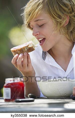 Little boy eating bread with jam outdoors View Large Photo Image Stock Photo - Little boy eating bread with jam outdoors. Fotosearch