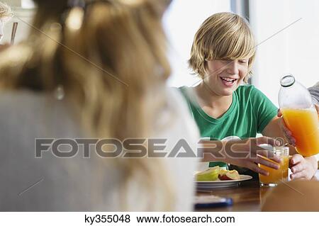 Teenage boy having breakfast at a dining table View Large Photo Image Stock Photo - Teenage boy having breakfast at a dining table. Fotosearch