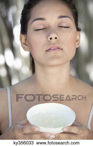 Beautiful young woman holding a bowl with bath salt View Large Photo Image Stock Image - Beautiful young woman holding a bowl with bath salt. Fotosearch