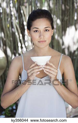 Picture - Portrait of a beautiful young woman holding a bowl. Fotosearch