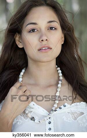 Portrait of a beautiful young woman wearing shell's necklace View Large Photo Image Stock Image - Portrait of a beautiful young woman wearing shell's necklace. Fotosearch