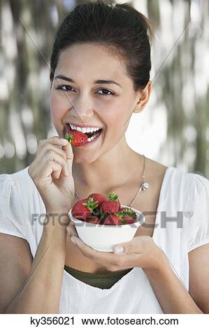 Portrait of a young woman eating strawberry View Large Photo Image Stock Image - Portrait of a young woman eating strawberry. Fotosearch