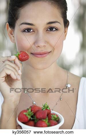 Portrait of a young woman holding a bowl of strawberries View Large Photo Image Stock Photo - Portrait of a young woman holding a bowl of strawberries. Fotosearch