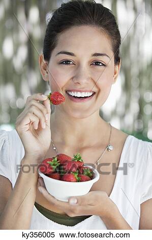 Portrait of a young woman holding a bowl of strawberries View Large Photo Image Stock Photography - Portrait of a young woman holding a bowl of strawberries. Fotosearch