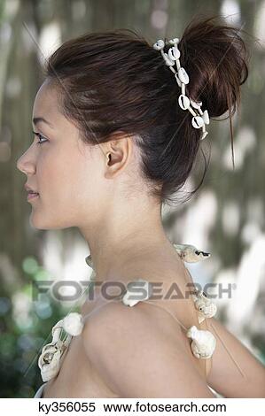 Side profile of a beautiful young woman wearing a shell necklace View Large Photo Image Stock Photography - Side profile of a beautiful young woman wearing a shell necklace. Fotosearch