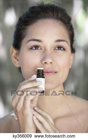 Young woman smelling aromatherapy oil View Large Photo Image Stock Photo - Young woman smelling aromatherapy oil. Fotosearch