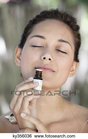 Young woman smelling aromatherapy oil View Large Photo Image Stock Photograph - Young woman smelling aromatherapy oil. Fotosearch