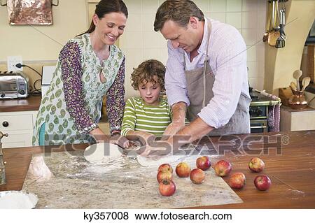 Cute little boy and his parents kneading dough at kitchen View Large Photo Image Stock Photo - Cute little boy and his parents kneading dough at kitchen. Fotosearch