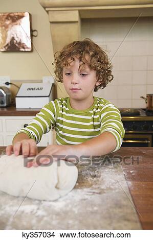Cute little boy kneading dough at kitchen View Large Photo Image Picture - Cute little boy kneading dough at kitchen. Fotosearch