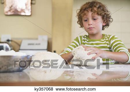 Cute little boy kneading dough at kitchen View Large Photo Image Stock Photo - Cute little boy kneading dough at kitchen. Fotosearch