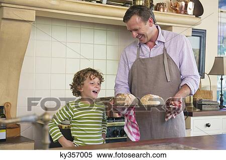 Cute little boy looking at bread in father's hand View Large Photo Image Stock Photography - Cute little boy looking at bread in father's hand. Fotosearch