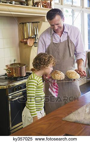 Cute little boy smelling baked bread in father's hand View Large Photo Image Stock Photography - Cute little boy smelling baked bread in father's hand. Fotosearch