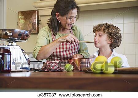Grandmother and little boy cooking food at home View Large Photo Image Stock Photo - Grandmother and little boy cooking food at home. Fotosearch