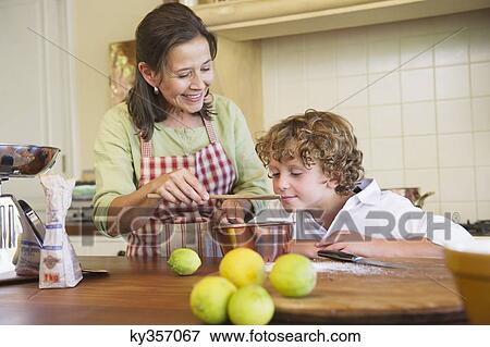 Grandmother and little boy cooking food at kitchen View Large Photo Image Stock Photo - Grandmother and little boy cooking food at kitchen. Fotosearch