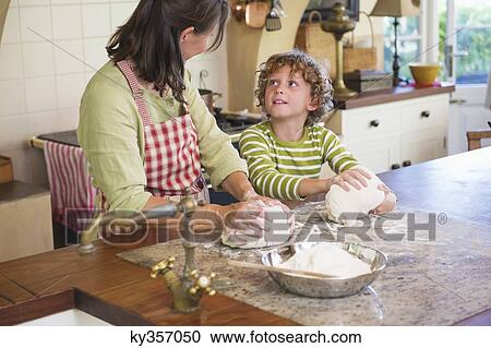Grandmother and little boy kneading dough at kitchen View Large Photo Image Stock Image - Grandmother and little boy kneading dough at kitchen. Fotosearch