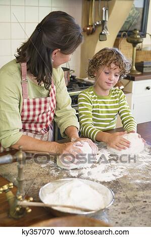 Grandmother and little boy kneading dough at kitchen View Large Photo Image Stock Image - Grandmother and little boy kneading dough at kitchen. Fotosearch