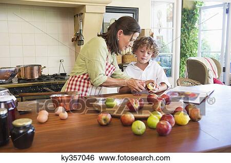 Grandmother and little boy peeling fruit at home View Large Photo Image Stock Photograph - Grandmother and little boy peeling fruit at home. Fotosearch