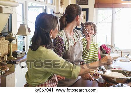 Multi generation family cooking food at kitchen View Large Photo Image Stock Image - Multi generation family cooking food at kitchen. Fotosearch