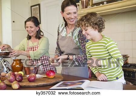 Multi generation family cooking food together at kitchen View Large Photo Image Stock Image - Multi generation family cooking food together at kitchen. Fotosearch