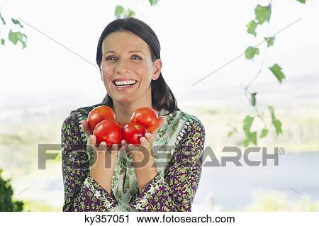 Portrait of a smiling mature woman holding tomatoes View Large Photo Image Stock Image - Portrait of a smiling mature woman holding tomatoes. Fotosearch